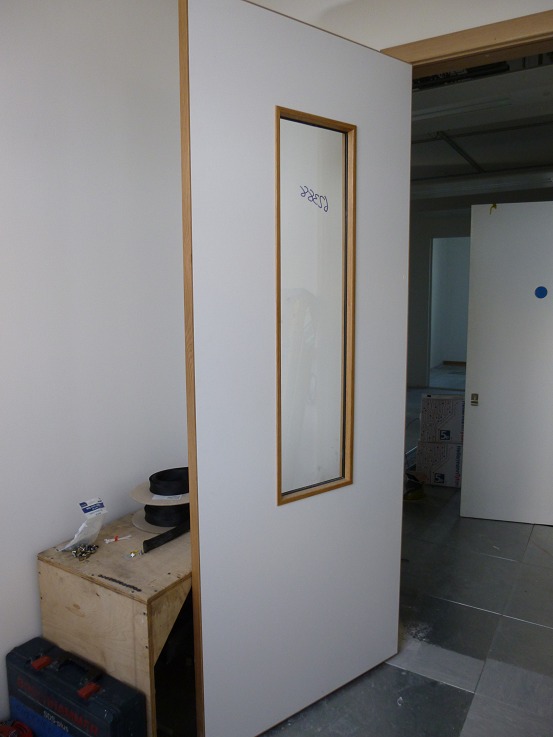 Acoustically sealed comms room door, with a viewing panel