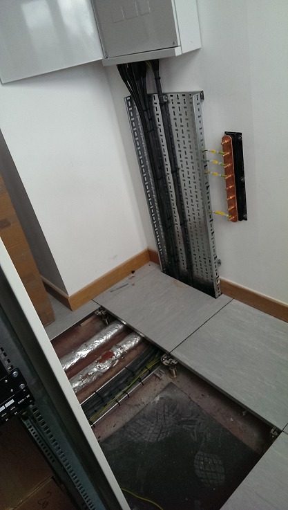 Cable tray running from the wall enclosure down into the floor void