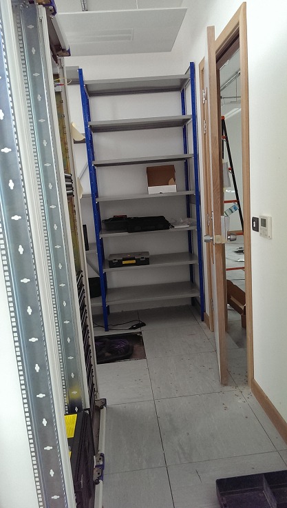 Variable-height steel shelving in the store room, dado supplying power and data alongside