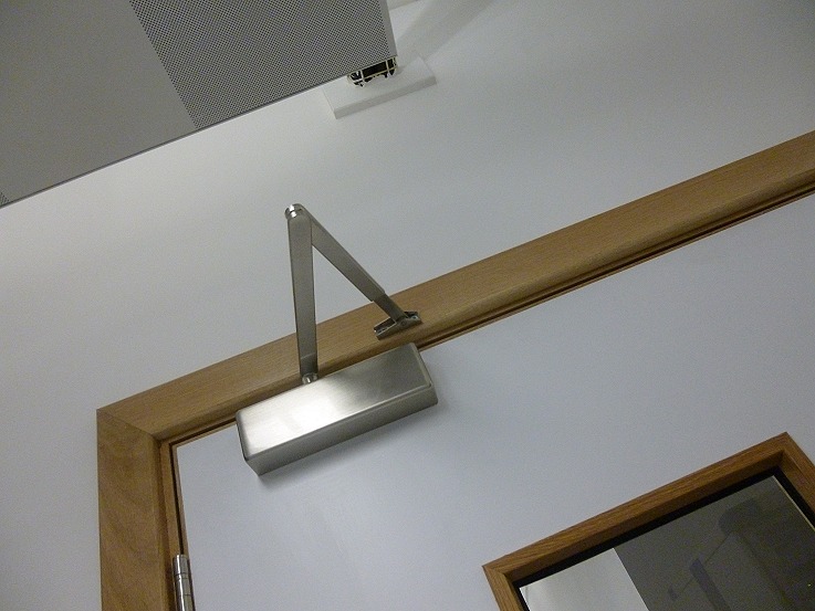 Overhead closer so the acoustic seal isn't left to a habit